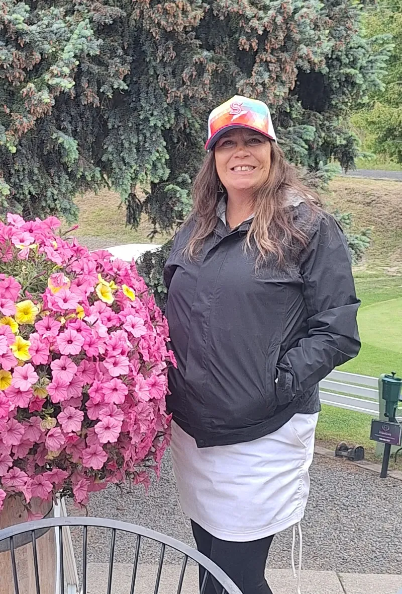Terra beside a barrel planter overflowing with petunias